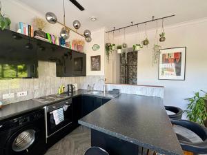 a kitchen with black cabinets and a black counter top at The Fishermans Daughters in Looe