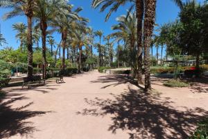 a walkway with palm trees and benches in a park at Sweetstaybykw Dean Llopez Stay in Santa Pola