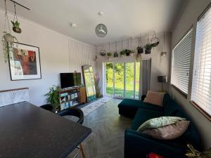 a living room with a green couch and a table at The Fishermans Daughters in Looe