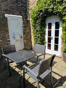 a table and two chairs with a table and a door at Quay Cottage in Sandwich, UK in Sandwich