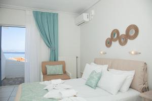 a bedroom with a bed and a chair and a window at The Milos in Megalochori