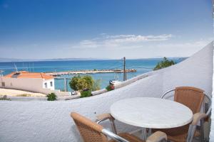 a table and chairs on a balcony overlooking the ocean at The Milos in Megalochori