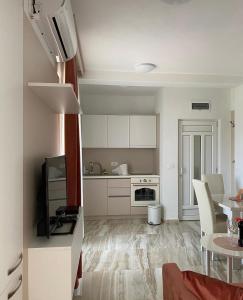 een keuken met witte kasten en een tafel in een kamer bij AS apartmani in Budva