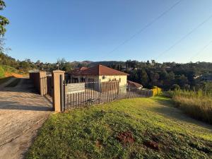 a fence in front of a house on a hill at Mountain Drive Apartments in Mbabane