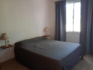 ein Schlafzimmer mit einem Bett und einem Fenster in der Unterkunft Cabañas La Viña in Chascomús