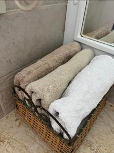 a basket with towels in a bathroom with a mirror at Domina Coral Bay Sultan 3 in Sharm El Sheikh