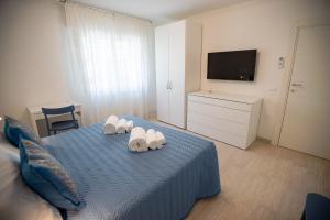 Un dormitorio con una cama azul con zapatos blancos. en CASA LILLY camere matrimoniali con bagno privato, en Chioggia