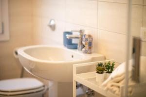 Un baño con un lavabo blanco y un inodoro. en CASA LILLY camere matrimoniali con bagno privato, en Chioggia 53 fotos más