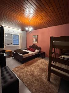 a bedroom with a bed and a couch in a room at Refugio Familiar em Monte Verde in Monte Verde