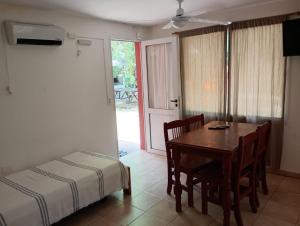 a bedroom with a table and a bed and a table and chairs at Cabañas La Viña in Chascomús