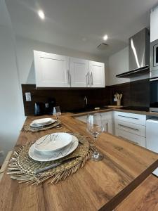 a kitchen with a table with plates and wine glasses at La Suite Vienne, chic et calme in Panazol +39 photos