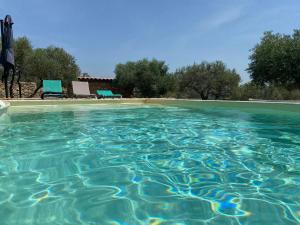 a pool of blue water with chairs and trees at PantaiaHomes - My Little Garden - Piscine - Vue panoramique in Tavernes +18 photos