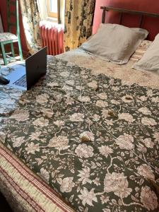 a bed with a laptop sitting on top of it at Fenêtre sur vue in Saignon