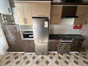 Una cocina con refrigerador y gabinetes de acero inoxidable. en Gurman Guest house by SamApart, en Samarkand