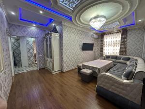 a large living room with a couch and a tv at Karimbek Guest house by SamApart in Samarkand