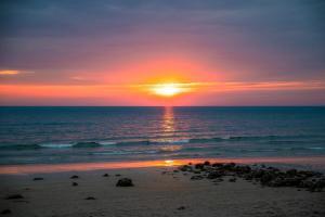 a sunset on the beach with the sun setting at Kacha Resort & Spa, Koh Chang in Ko Chang