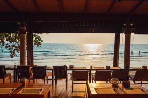 a restaurant with tables and chairs on the beach at Kacha Resort & Spa, Koh Chang in Ko Chang