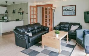 a living room with a leather couch and a table at 3 Bedroom Beautiful Home In Toftlund in Toftlund