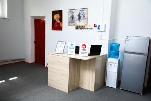 an office with a desk and a refrigerator at Yassi HOSTEL in Türkistan