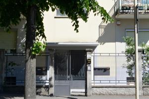 un bâtiment blanc avec un portail et une clôture dans l'établissement Rooms Of Love, à Pavia