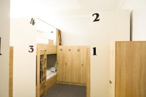 a room with numbers on the wall and two bunk beds at Yassi HOSTEL in Türkistan