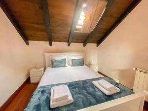 Un dormitorio con una cama blanca con techo de madera. en Petras Madeira Hideaway, en Santo da Serra