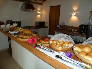 a kitchen counter with bread and baskets of food on it at Jardim de Trancoso Pousada in Trancoso