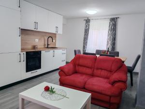 a living room with a red couch and a table at Kuća za odmor Kupa in Vrbovsko