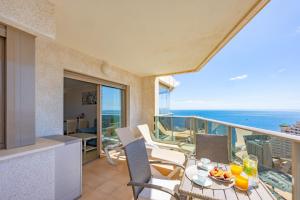 Un balcón con mesa y sillas y el mar. en Apartment of Joy Piscina Aparcamiento, en Calpe