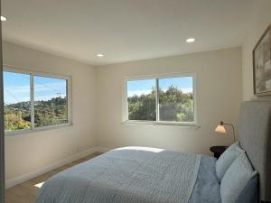 a bedroom with two windows and a bed in it at Vista Haven in Santa Babara in Santa Barbara