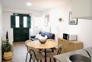 un piccolo soggiorno con un tavolo e una cucina di Blue House in the Old Town Setúbal a Setúbal