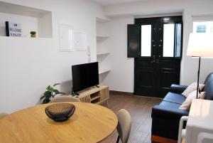 un soggiorno con un tavolo e un divano blu di Blue House in the Old Town Setúbal a Setúbal