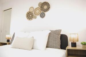 una camera da letto con un letto con lenzuola e cuscini bianchi di Blue House in the Old Town Setúbal a Setúbal