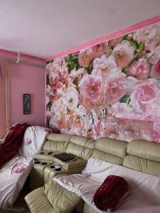 a living room with a couch and a flower mural at Otthon in Budaörs