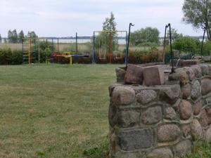 a stone wall with a playground in a field at Lütow, Zum Möwenort 15 WE 2 in Lütow