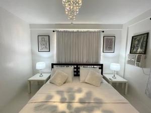 a bedroom with a large bed with two tables and two lamps at Your second home in Tagbilaran in Tagbilaran City