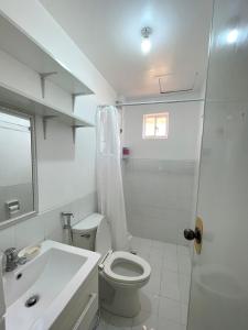 a white bathroom with a toilet and a sink at Your second home in Tagbilaran in Tagbilaran City +13 photos