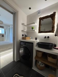 a bathroom with a sink and a washing machine at Pyrgaki hideway in Agiassos