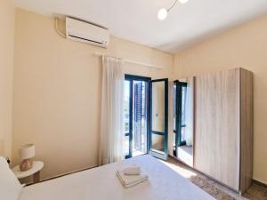 a bedroom with a white bed and a large window at Porto Blue Horizon in Pefkohori +12 photos