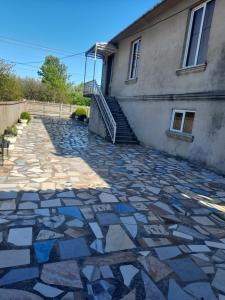 Un camino de piedra frente a un edificio con una escalera. en Zhanas home, en Anaklia