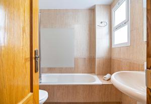a bathroom with a tub and a toilet and a sink at Elegante piso en la Romanilla in Roquetas de Mar