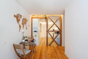 a room with a table and a door with a world map on the wall at Central Bedroom in Shared House in Chiado - Historic Center of Lisbon in Lisbon