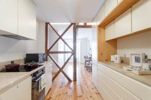 a kitchen with white cabinets and a wooden floor at Central Bedroom in Shared House in Chiado - Historic Center of Lisbon in Lisbon
