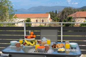 a table with fruit and drinks on a balcony at Vangel House in Chaliotata