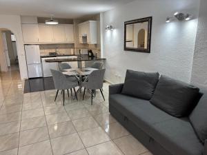 a living room with a couch and a table and a kitchen at Casa Serena in Los Cristianos