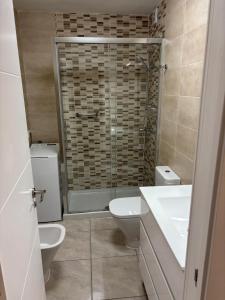 a bathroom with a shower and two sinks and a toilet at Casa Serena in Los Cristianos +5 photos