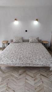 a large bed in a room with two tables at Alegria rustica 2 Rustic happiness in Envendos