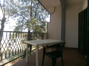 a white table and a chair on a balcony at messina in Lido di Spina