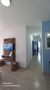 a hallway of a living room with a tv at Cabo Frio frente Mar 03qt in Cabo Frio