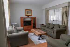 a living room with a couch and chairs and a table at Gran Hotel Continental in Cajamarca